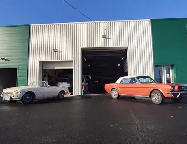 Deux voitures décapotables classiques, une MGB et une Mustang, devant un garage à Veigné près de Tours en Indre-et-Loire 37